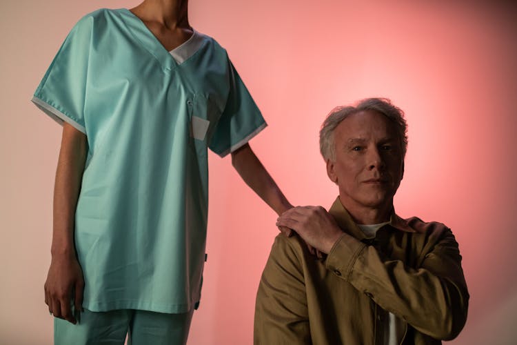 Nurse Holding Hand Of Elderly Man