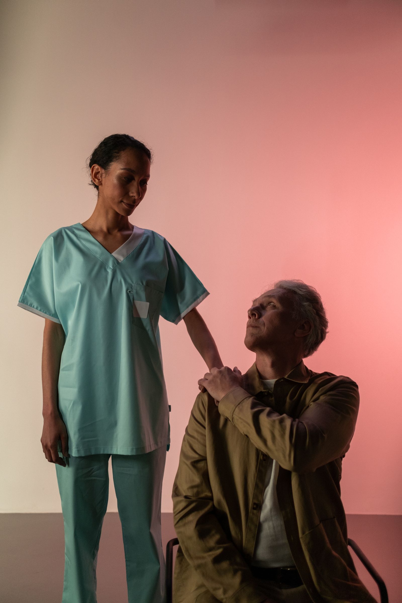 A nurse supporting an elderly patient on the ward