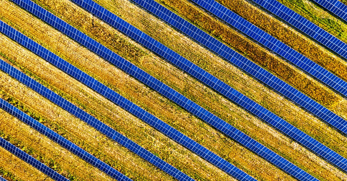 A split image showing a smoky coal plant on one side and a field of solar panels on the other, with a calendar showing 2040 circled in red