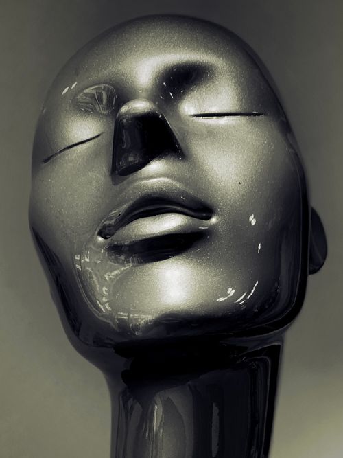 Free Close-up view of a sleek black mannequin head with a serene expression and elegant design. Stock Photo