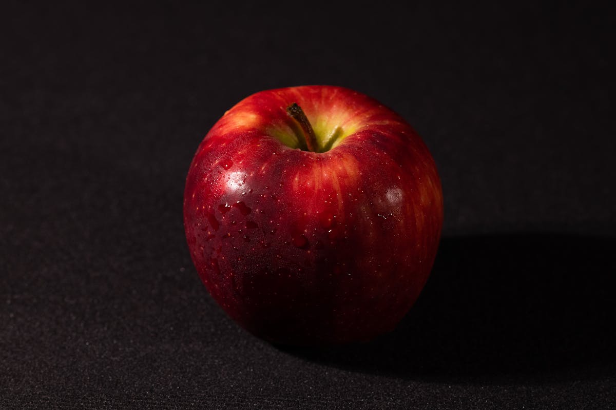Person holding a shopping basket filled with fresh fruits and vegetables in a supermarket