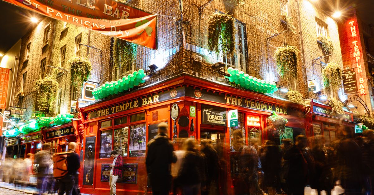 Lively night scene at the iconic Temple Bar in Dublin, showcasing St. Patrick's Day celebrations.