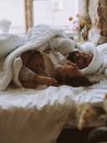 Man Smiling in Bed with Woman