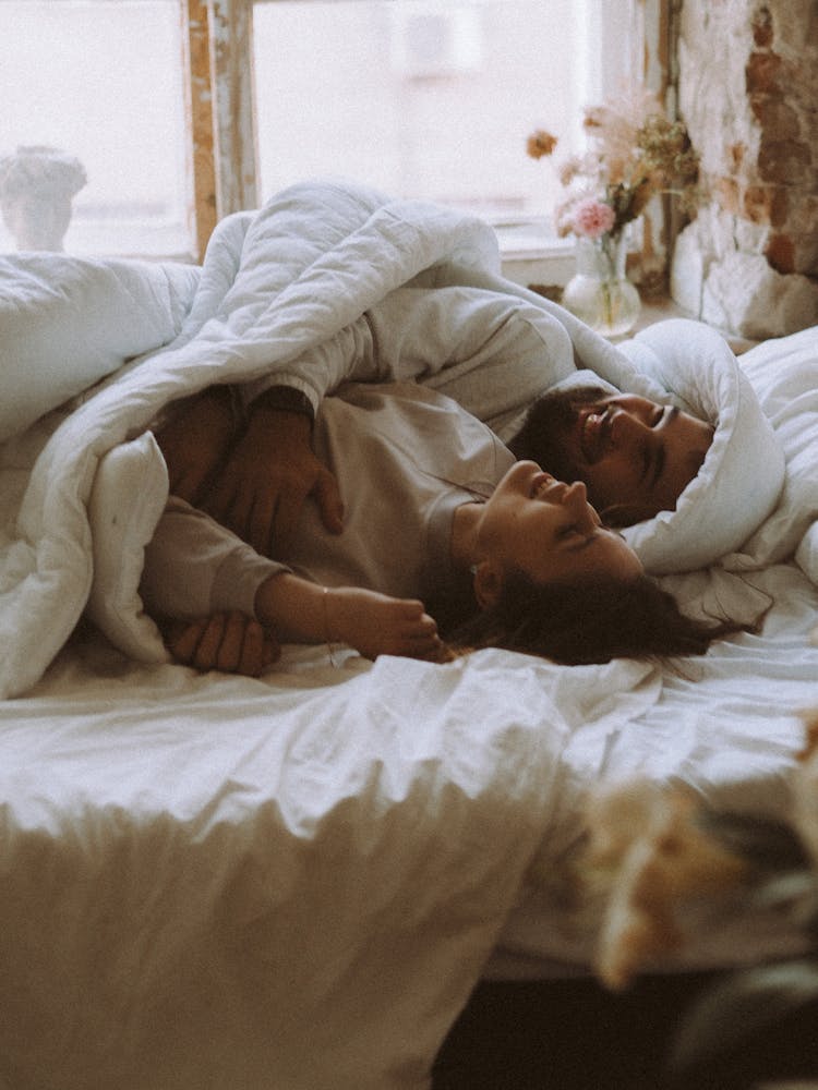 Man Smiling In Bed With Woman