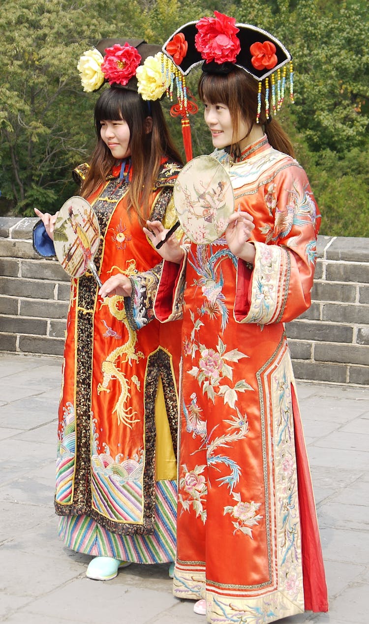 Women In Traditional Clothes Posing While Holding Fans