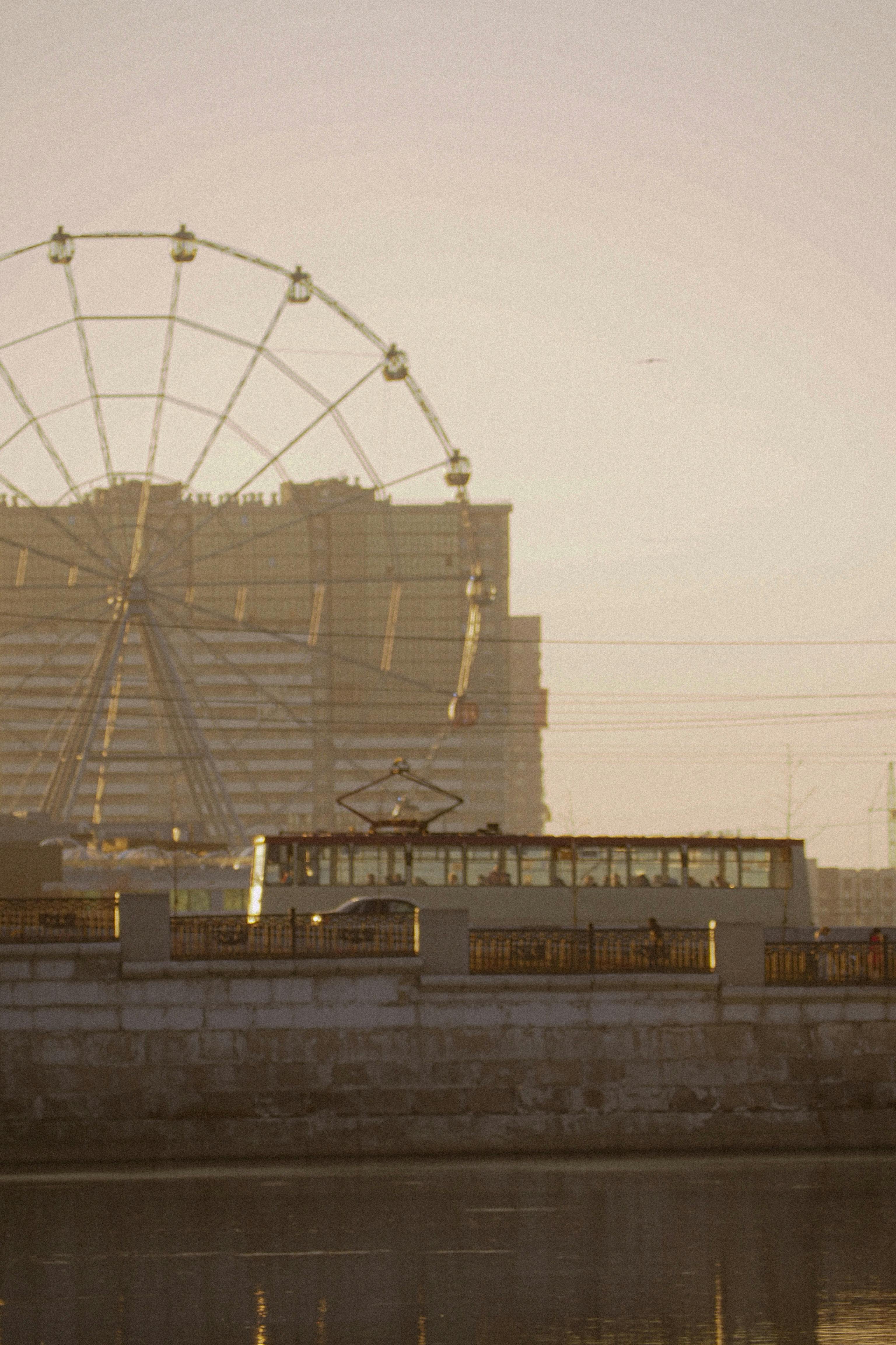 Early morning view of a tram and Ferris wheel in Chelyabinsk, Russia, capturing the city's unique transportation and skyline.