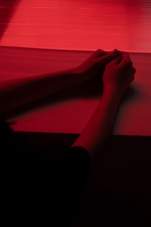 Human Arms on Table with Red Light