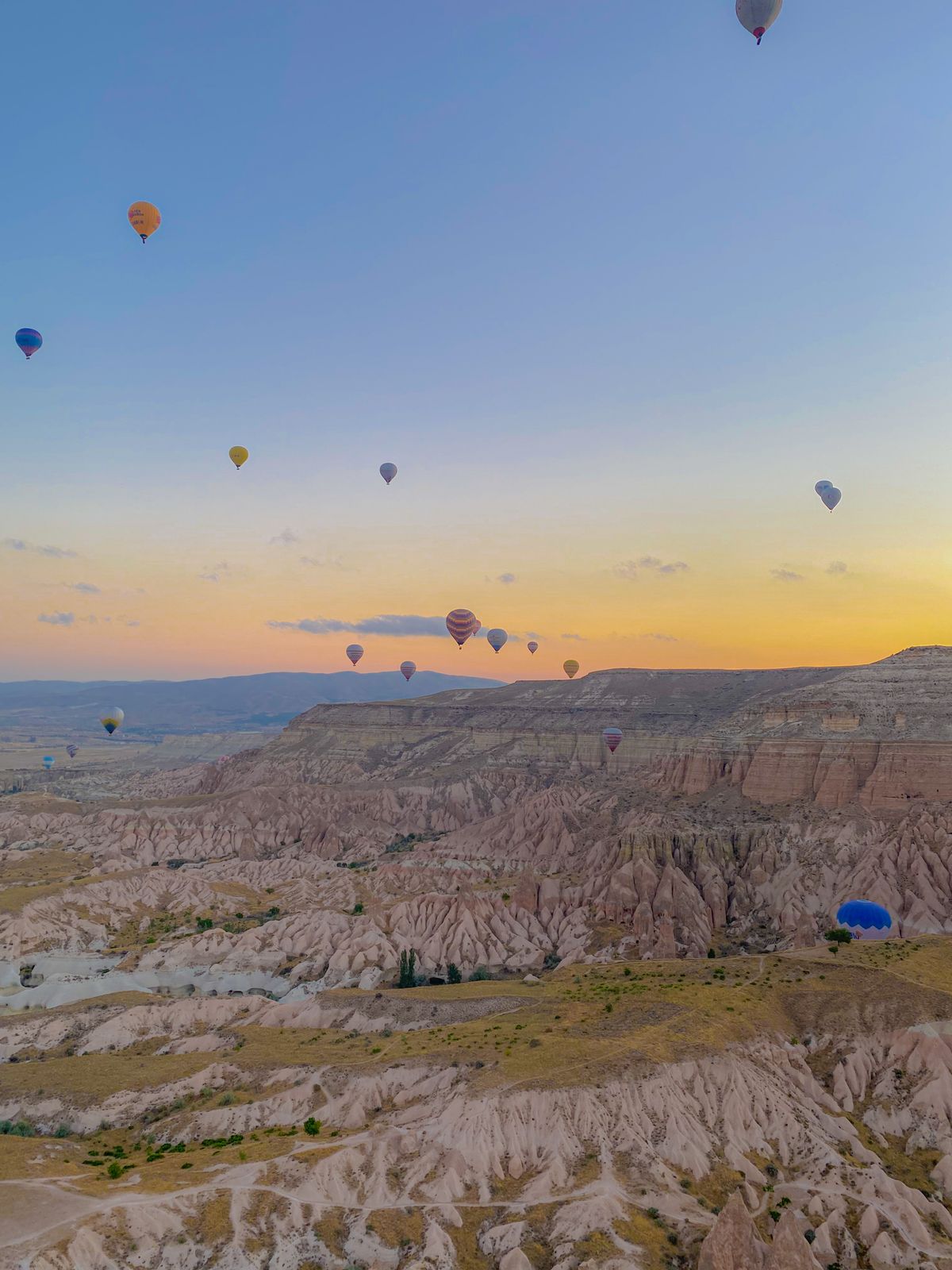 Hot air balloons floating over Cappadocia's unique rock formations at sunrise
