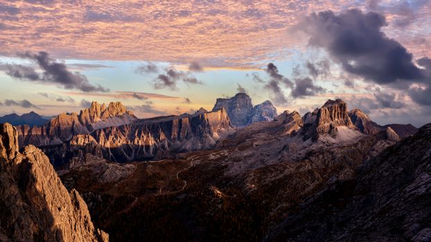 Breathtaking view of the Dolomites with a dramatic cloudy sky at sunset in Veneto, Italy.