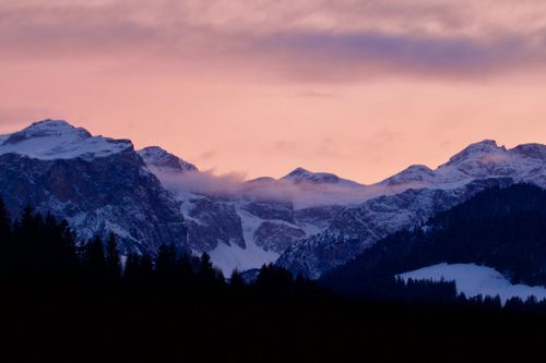Free Silhouette of snowy mountains with a pink sunrise sky in Trentino-Alto Adige, Italy. Stock Photo