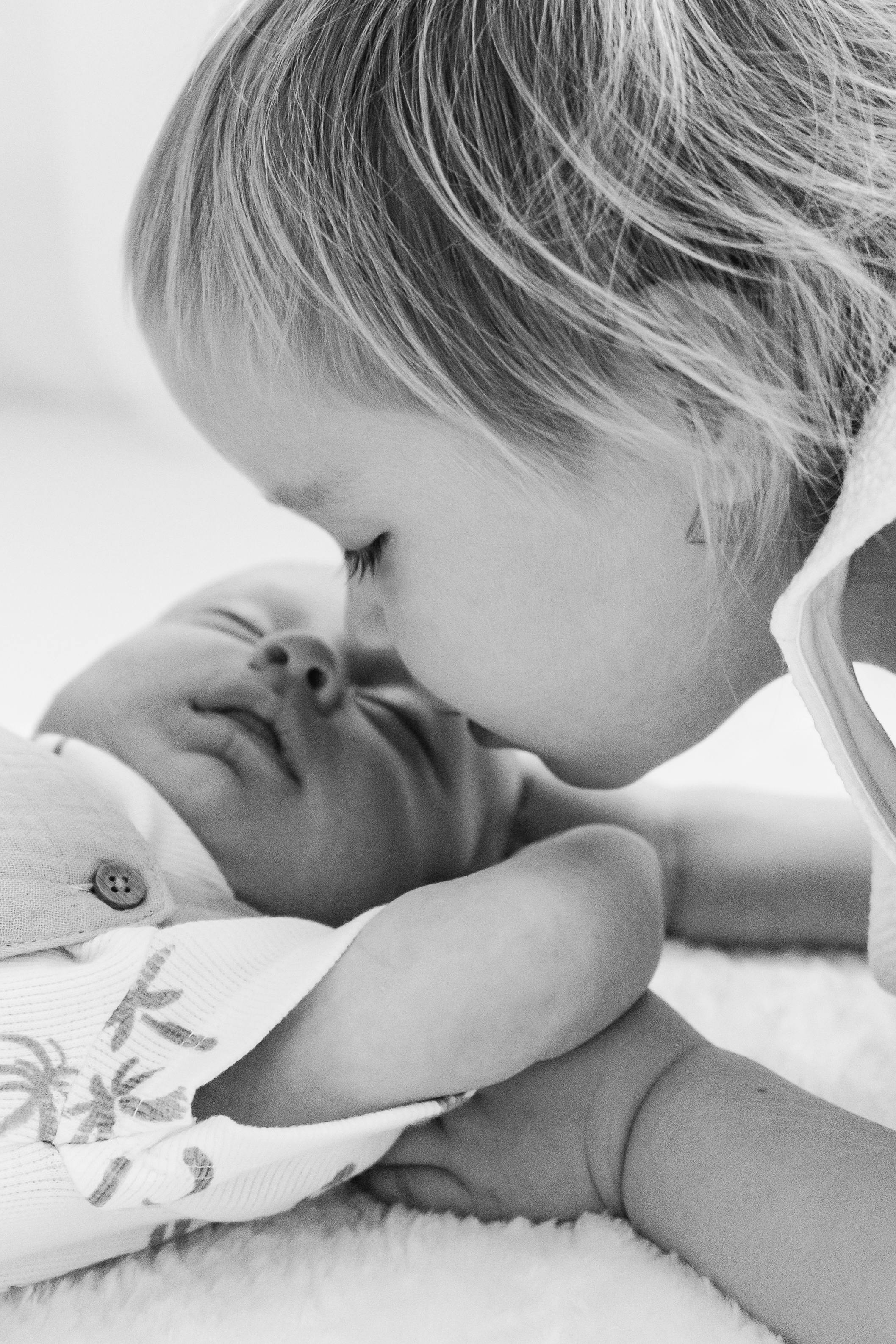 premature child kissing a new born