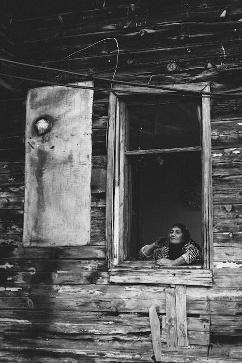 Woman in the Window in a Wooden House