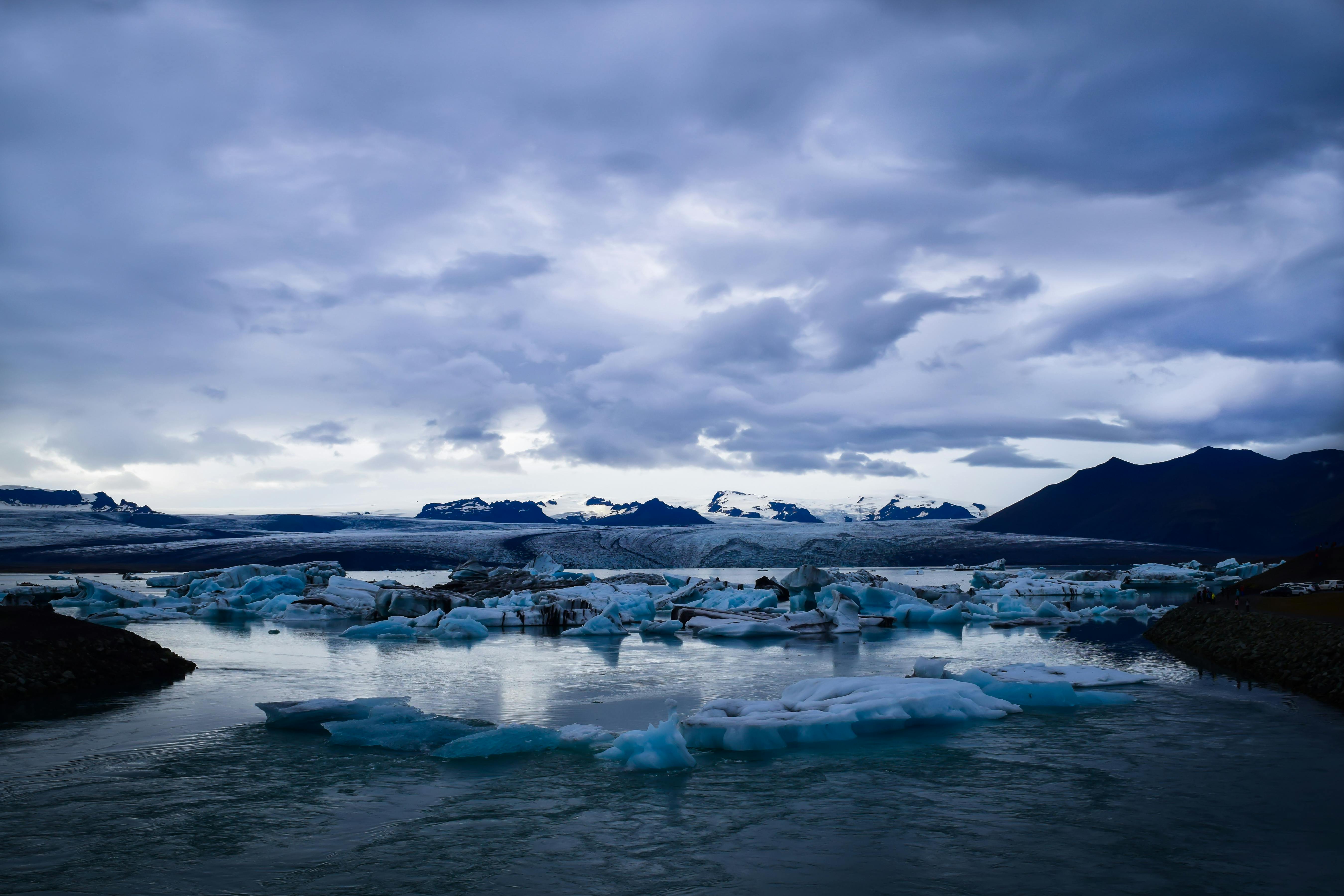 Ice on a Body of Water Near Snowy Mountains · Free Stock Photo