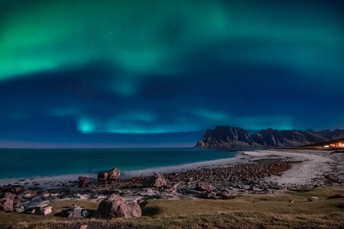 Free Capture the ethereal beauty of the Northern Lights illuminating the rocky coastline in Nordland, Norway. Stock Photo