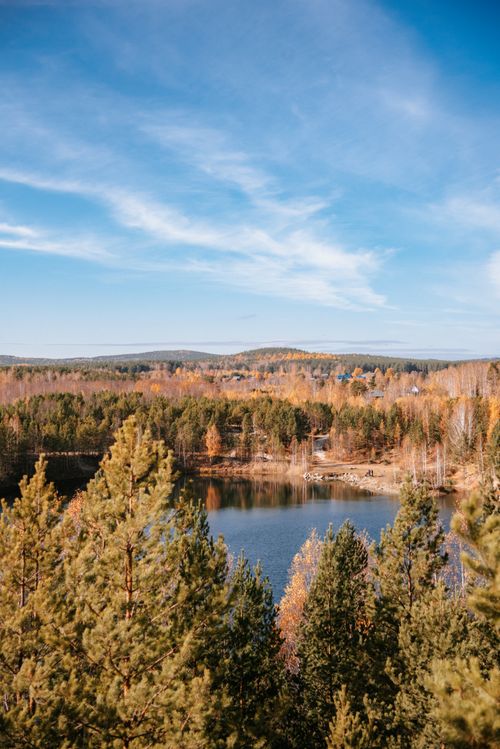 Free A tranquil lake view with autumn foliage under a clear blue sky. Stock Photo