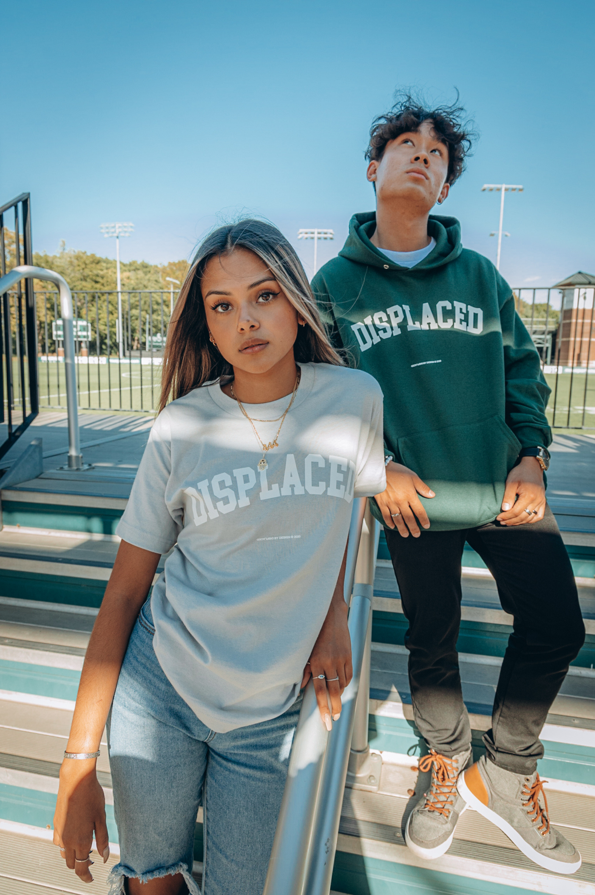Fashionable young adults in stylish outfits posing outdoors in urban setting.