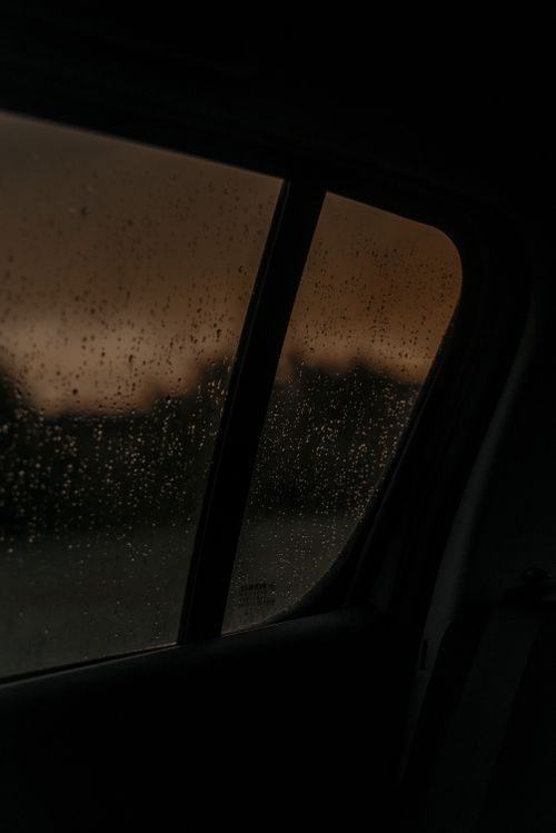 Free Raindrops on a car window create a moody scene at dusk, highlighting the serene ambiance. Stock Photo