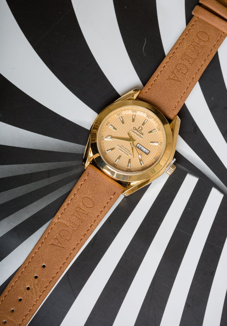 A Gold Omega Wristwatch With Brown Suede Straps