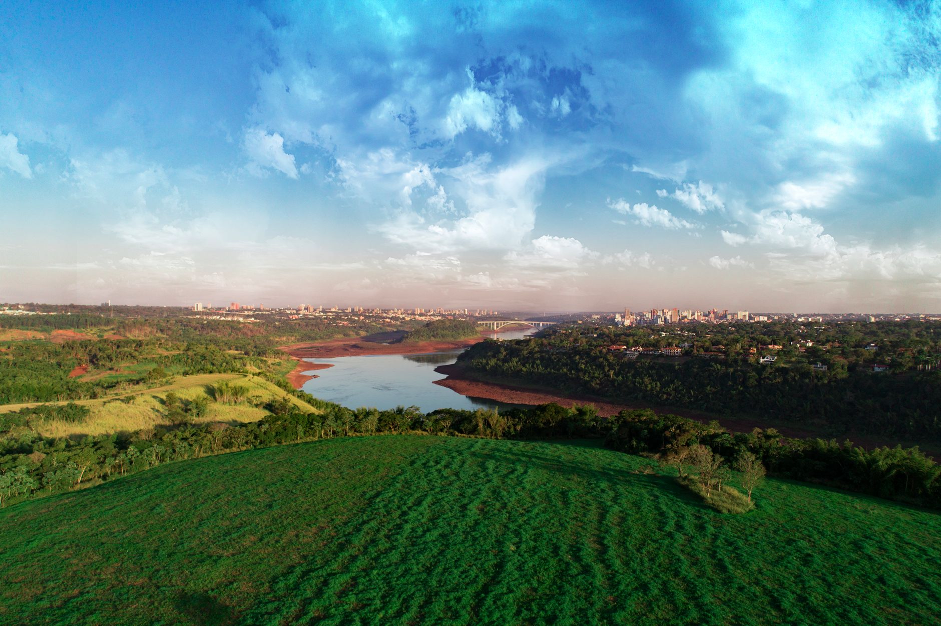 A breathtaking view of the river and landscape in Foz do Iguaçu, Brazil, under a vibrant sky.