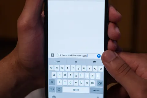 Close-up of hands holding a smartphone with a messaging app open