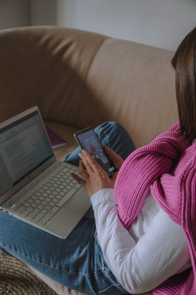 Woman Sitting On Couch And Holding Phone In Hand