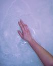 A Person Touching the Soap Foam on Water