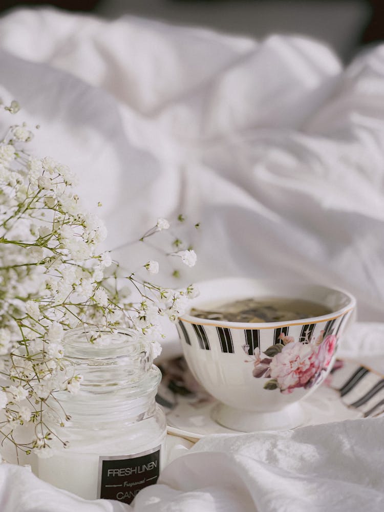 Cup Of Green Tea With Scented Candle On Beige Background