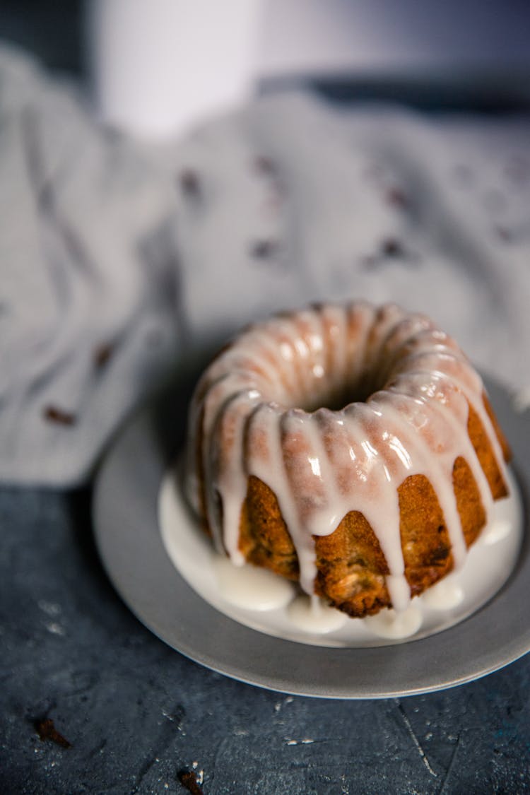 Muffin With Glaze Dripping Onto Plate