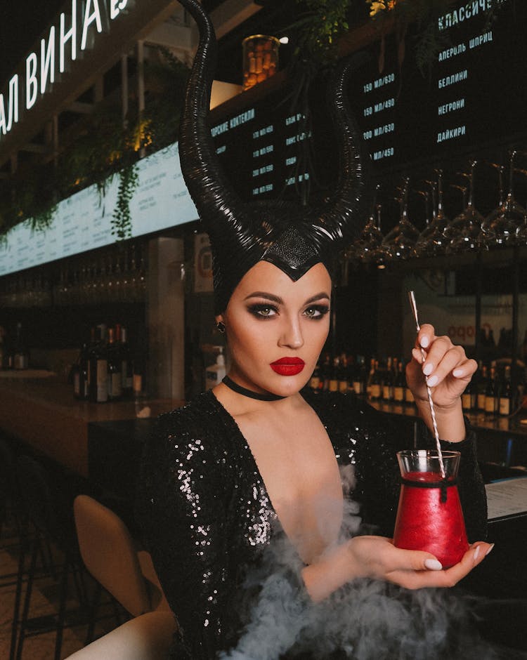 Woman In Black Costume Holding Drink