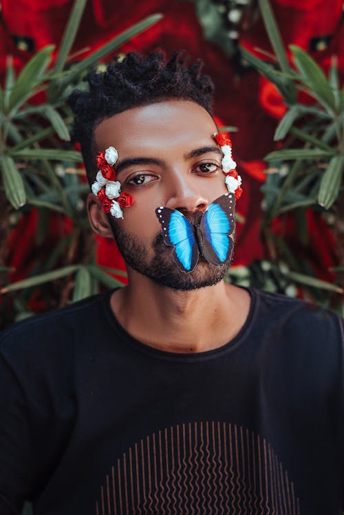 Man with Exotic Butterfly on His Mouth and Flowers on His Temples