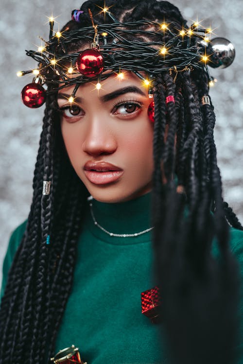 A Pretty Woman Wearing a Crown of Christmas Lights with Baubles