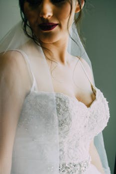 Close-up of a bride in a lace wedding dress with red lipstick, exuding elegance and charm.