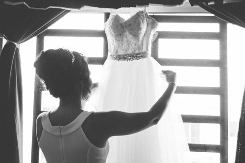 Free Bride admires her wedding dress in a bright, monochrome setting. Stock Photo