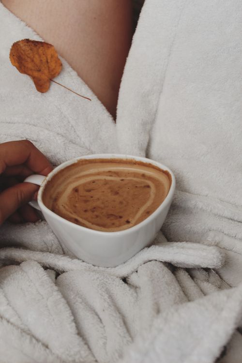 Free A relaxing scene with a cup of coffee, dry leaf, and a white bathrobe perfect for autumn coziness. Stock Photo