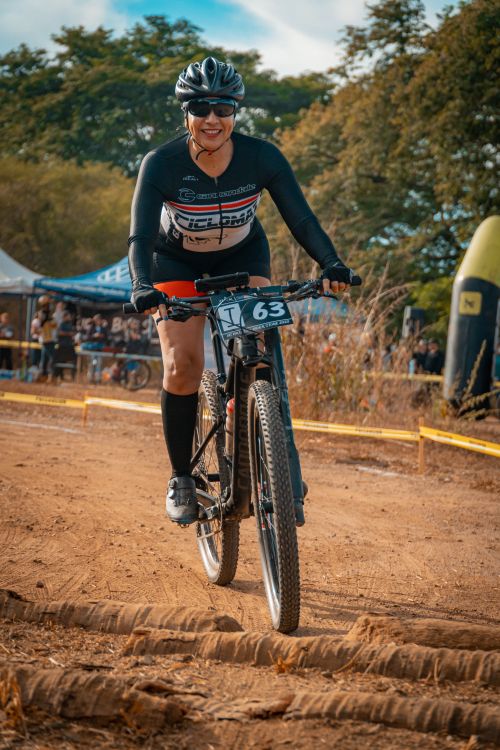 Free Woman cyclist competes in an outdoor mountain biking race amidst nature. Stock Photo