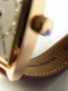 Gray Analog Watch With Brown Leather Strap on White Pad