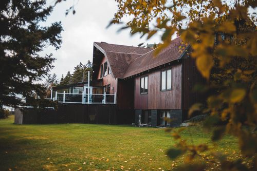 Free Beautiful wooden house surrounded by autumn foliage, showcasing seasonal charm. Stock Photo