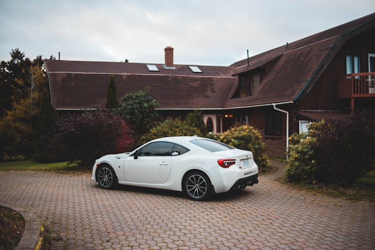 White Car Parked In Front Of House