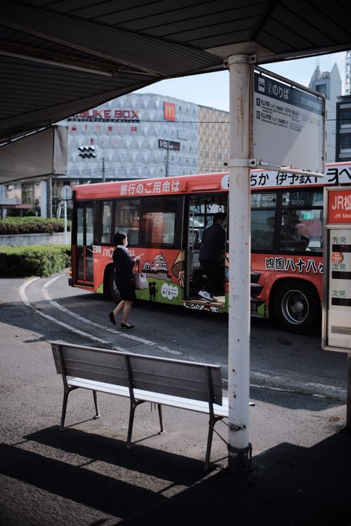 Free City bus stop scene with passengers boarding during daytime reflecting urban life and public transport. Stock Photo