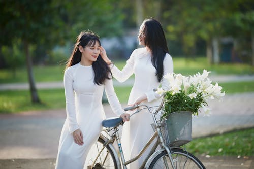 Gratis lagerfoto af cykel, folk, hvid kjole