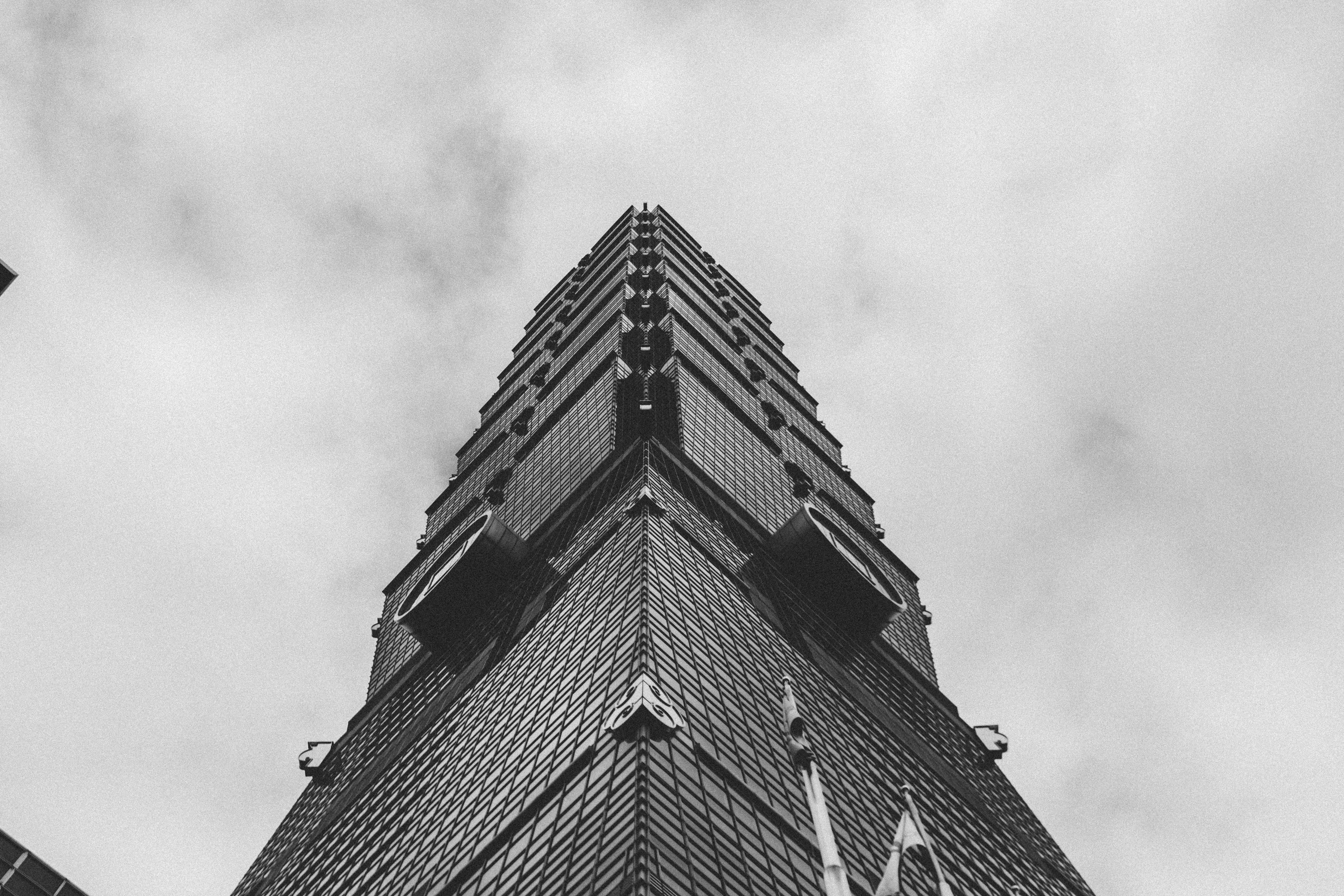 在多云天空的映衬下，以低角度拍摄高耸的摩天大楼，画面极具戏剧性