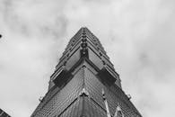 在多云天空的映衬下，以低角度拍摄高耸的摩天大楼，画面极具戏剧性