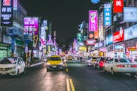 夜晚，繁华的城市街道上，霓虹灯充满活力，交通繁忙，描绘出热闹的城市夜生活