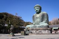 A Green Buddha Statue in a Brick Pedestal