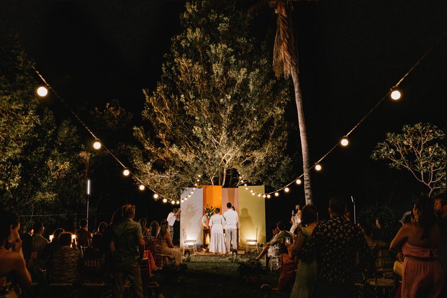 Evening outdoor gathering under string lights and trees