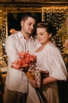 Romantic couple embracing indoors with flowers and soft lighting, conveying love and togetherness.