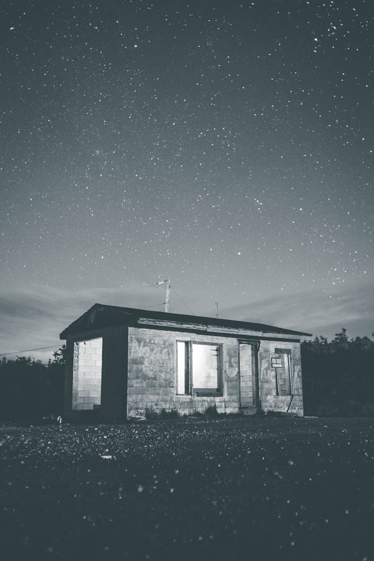 Black And White Photo Of Small Building At Night