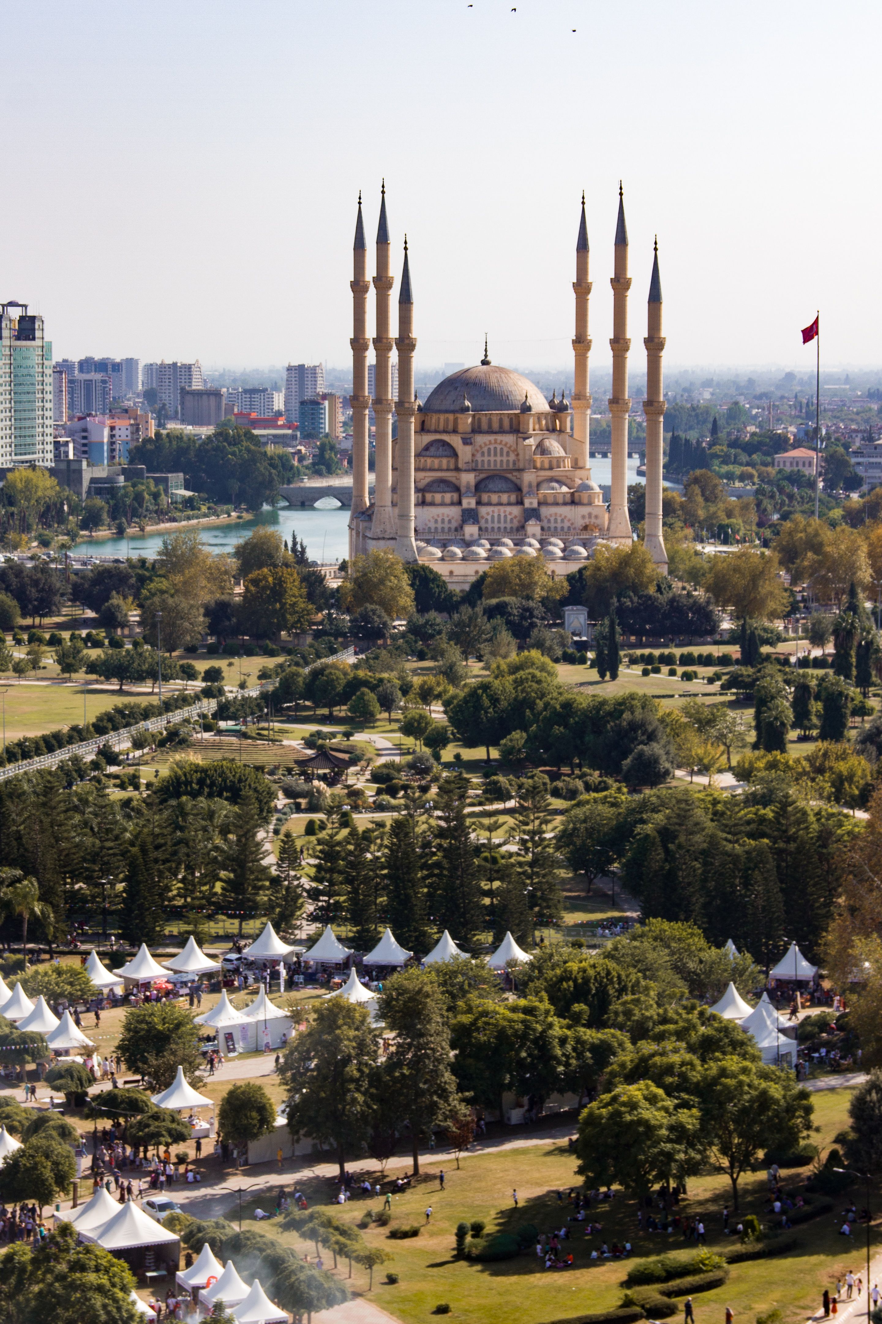 Stunning aerial view of the Sabancı Merkez Mosque and public park in Adana, Turkey, showcasing city and nature.