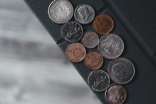 Free A flat lay image showcasing a diverse array of international coins laid on a textured surface. Stock Photo