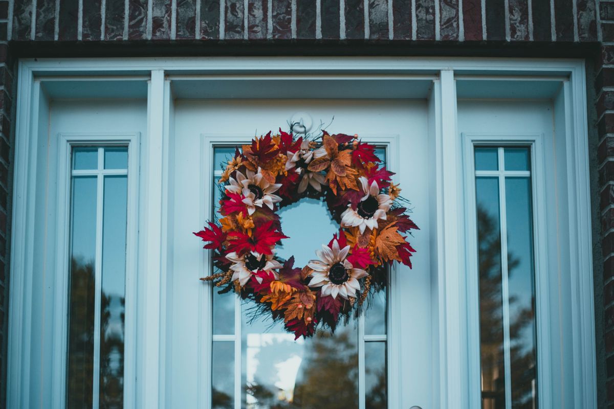 Colorful autumn wreath full of faux leaves on a front door